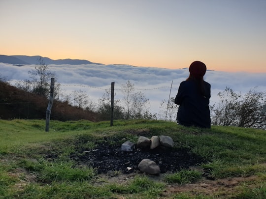 man sitting on grass facing the sea of clouds in Amlash Iran