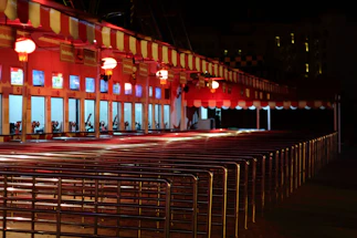 A warmly lit concert ticket booth with ambient string lights at dusk