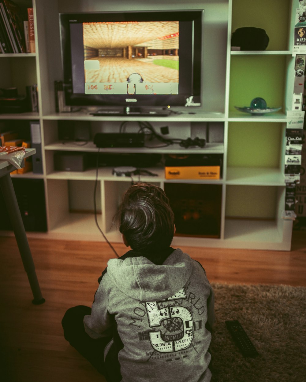 boy sitting on floor infront of TV