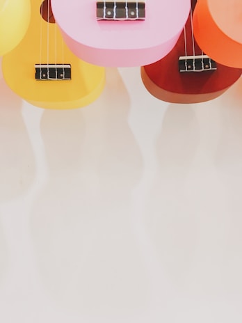 A lively group ukulele class with smiling faces and colorful instruments.