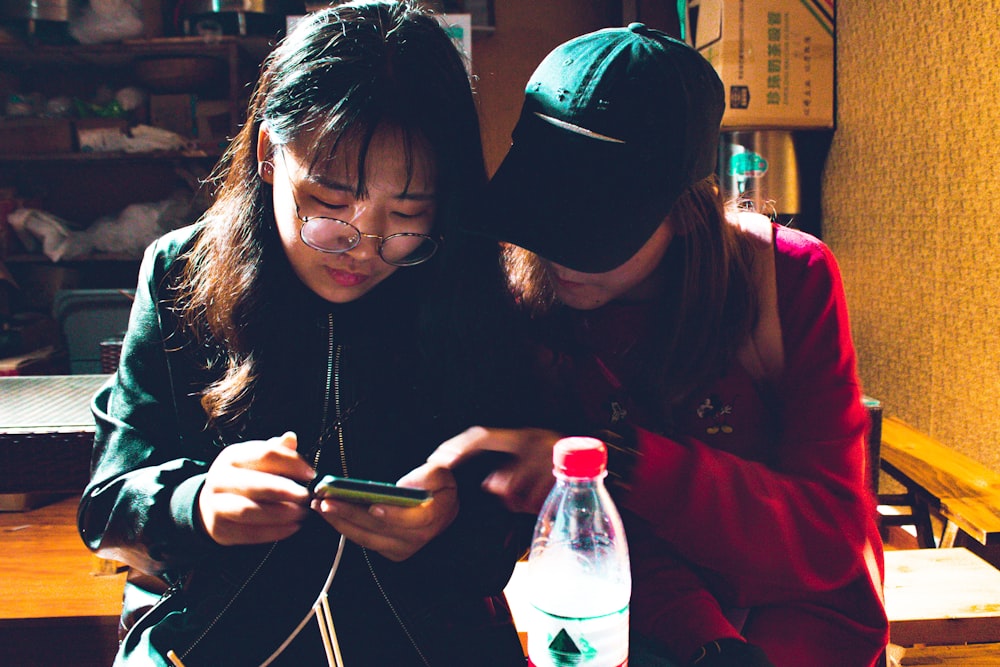 duas mulheres olhando para um smartphone