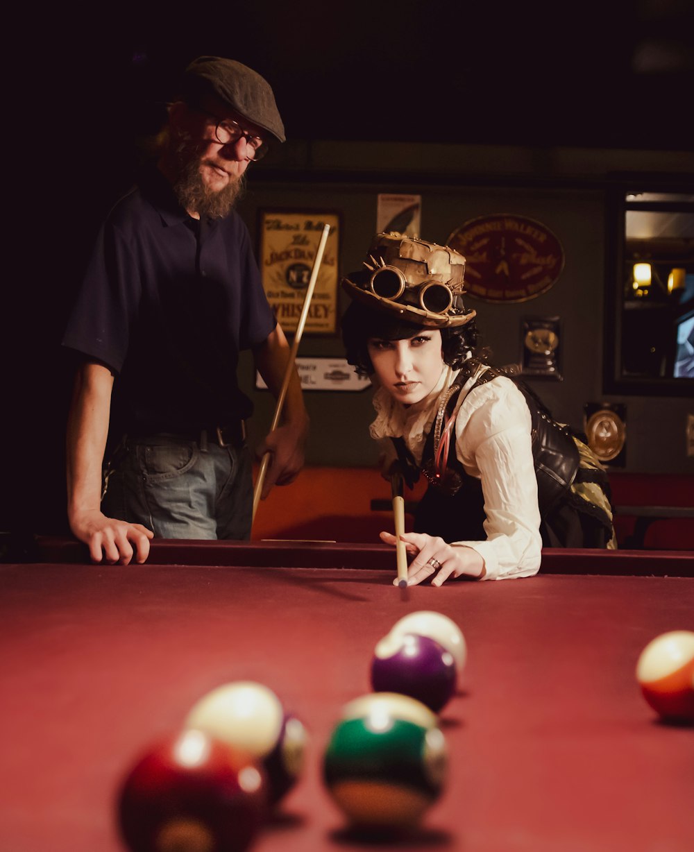 woman playing billiard near man