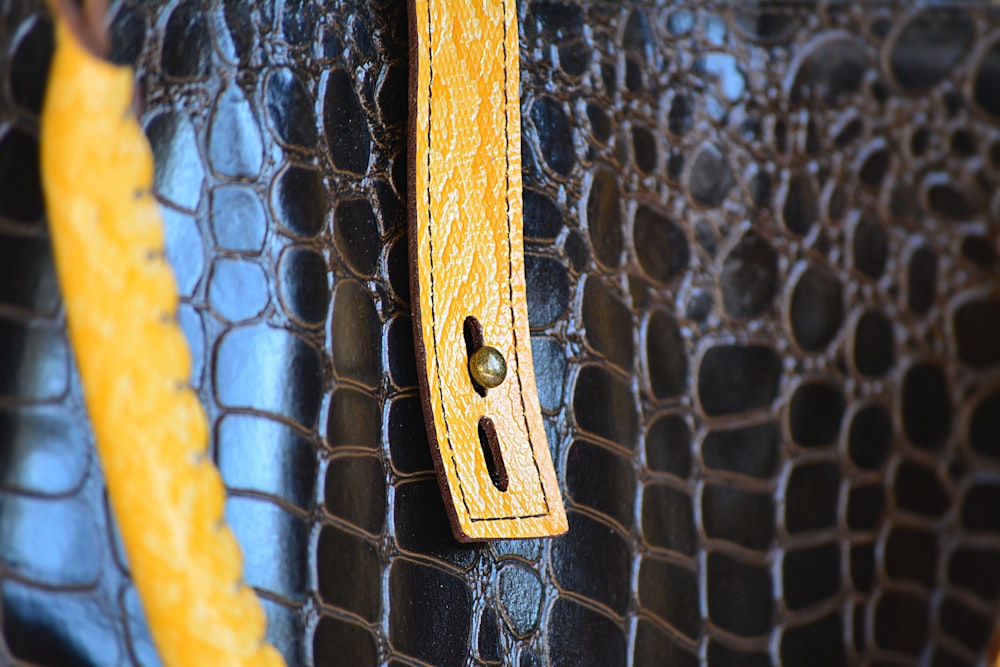 a close up of a yellow handle on a black purse