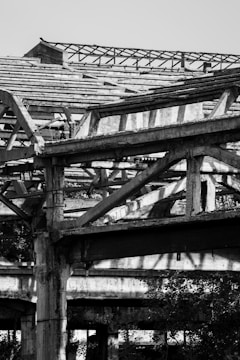 Before image of a decaying industrial unit surrounded by overgrowth.