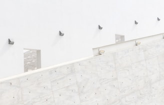 Minimalist architectural wall wash lighting illuminating a textured neutral-toned wall with soft shadows