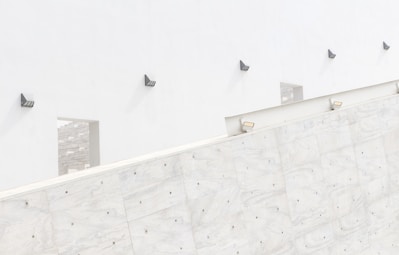 Minimalist architectural wall wash lighting illuminating a textured neutral-toned wall with soft shadows