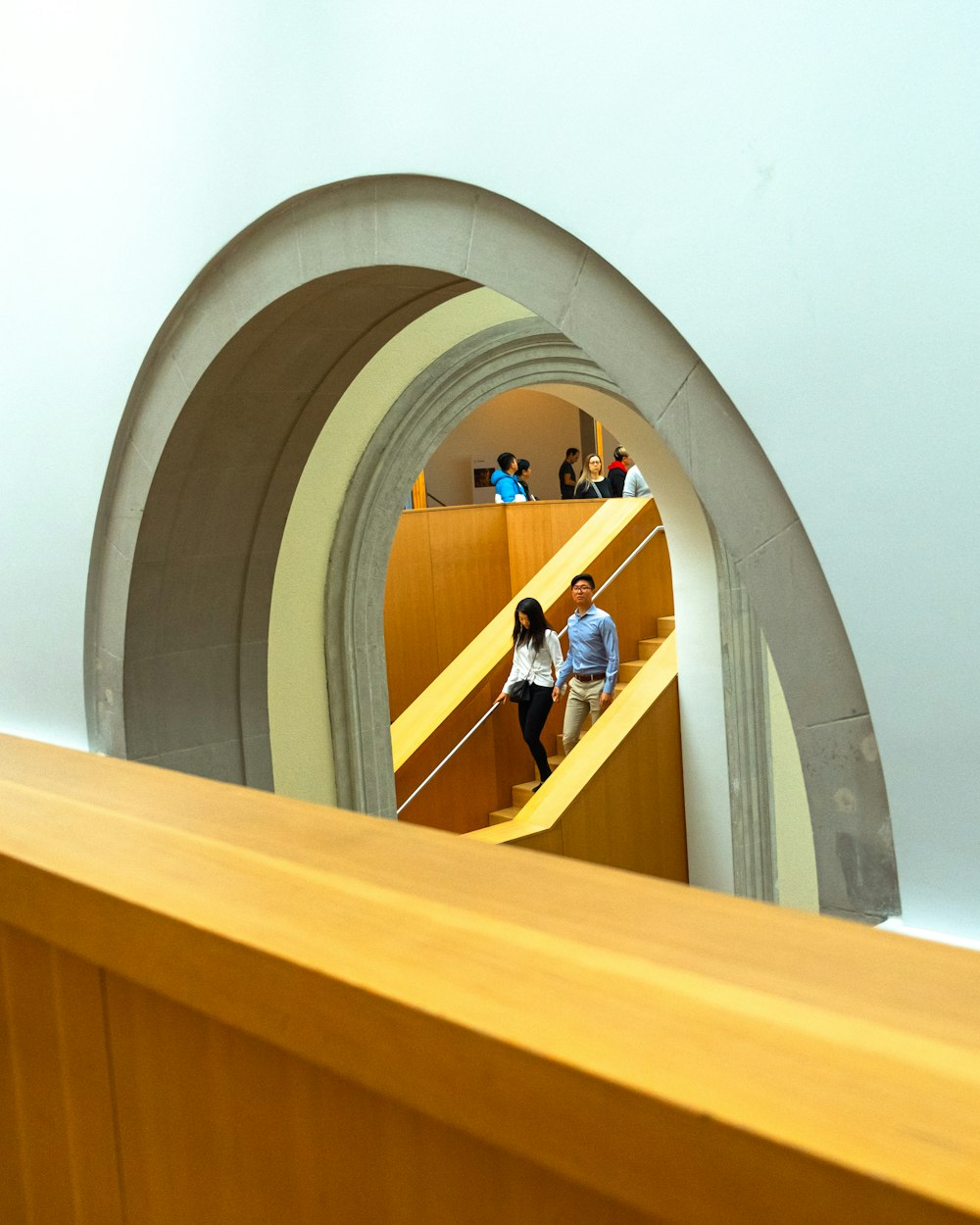 Mann in schwarzem T-Shirt und blauer Jeans steht auf gelber Treppe