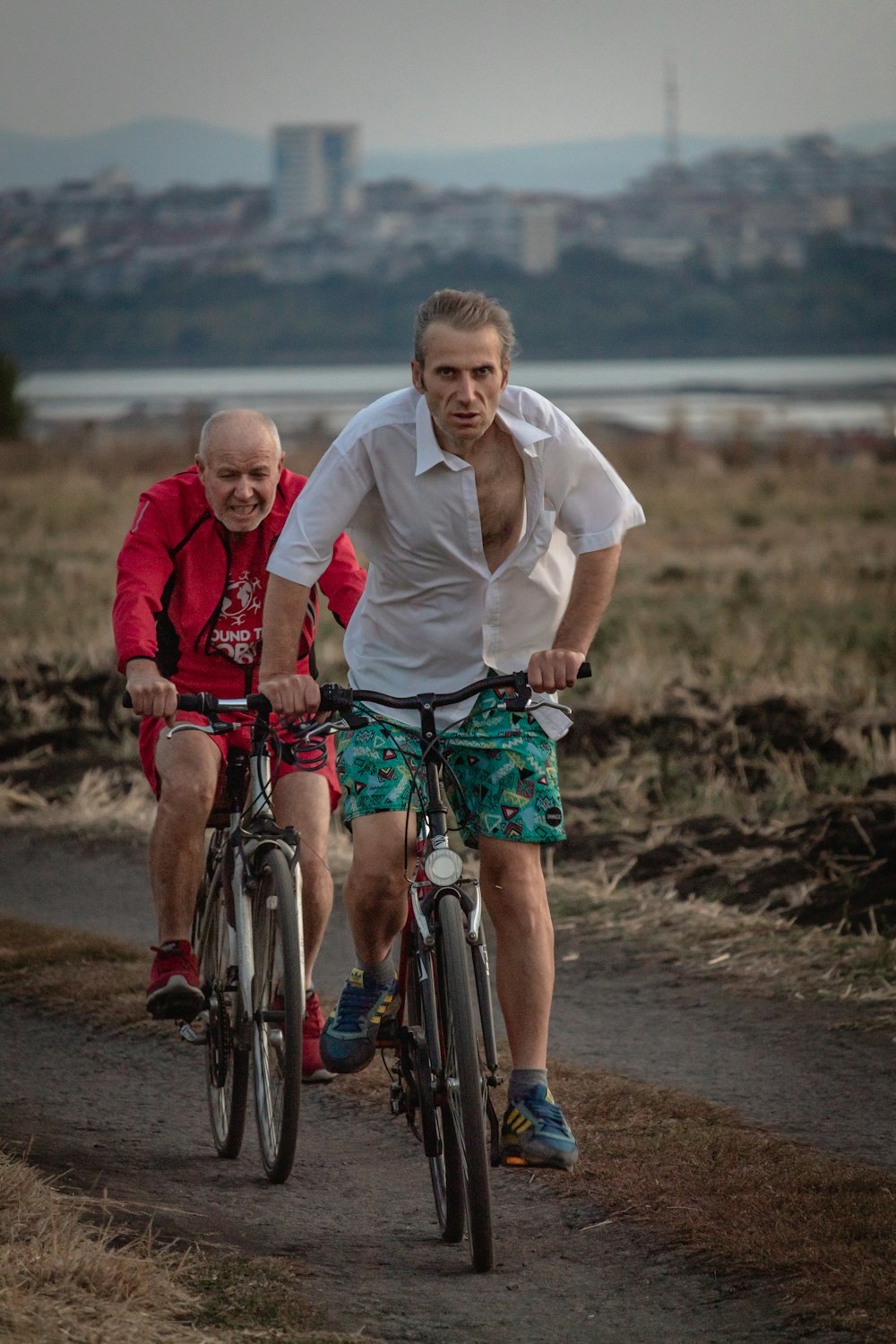 foto de enfoque superficial de hombre en camiseta blanca abotonada montando en bicicleta