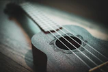 A close-up of hands skillfully plucking ukulele strings during a workshop.