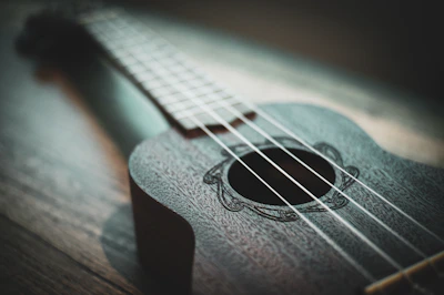 A close-up of hands skillfully plucking ukulele strings during a workshop.