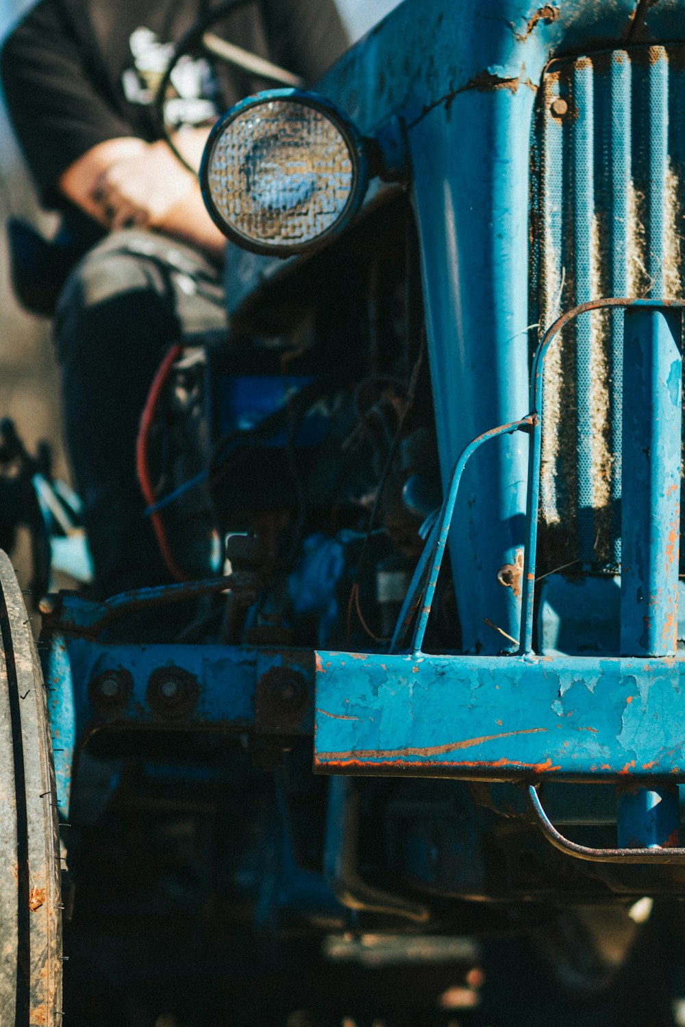 person sitting on blue tractor