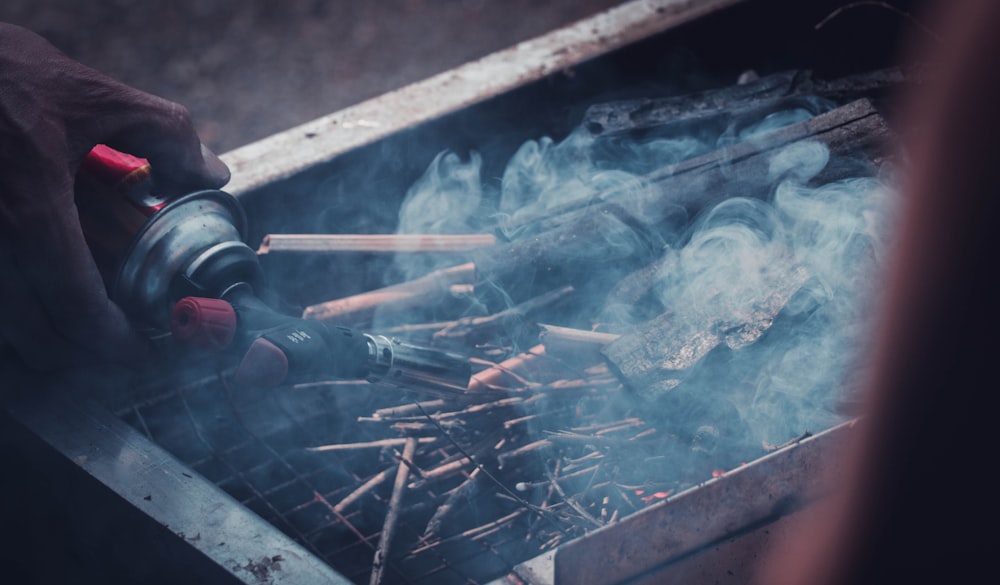 uma pessoa está cozinhando em uma grelha com fumaça