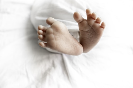 a close up of a baby's bare feet on a bed