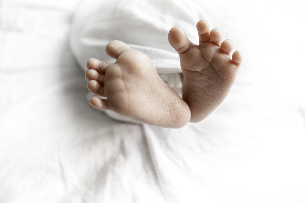a close up of a baby's bare feet on a bed