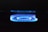 A blue flame from a gas stove burner is prominently displayed against a dark background. The flame forms a circular pattern with a soft, glowing appearance.