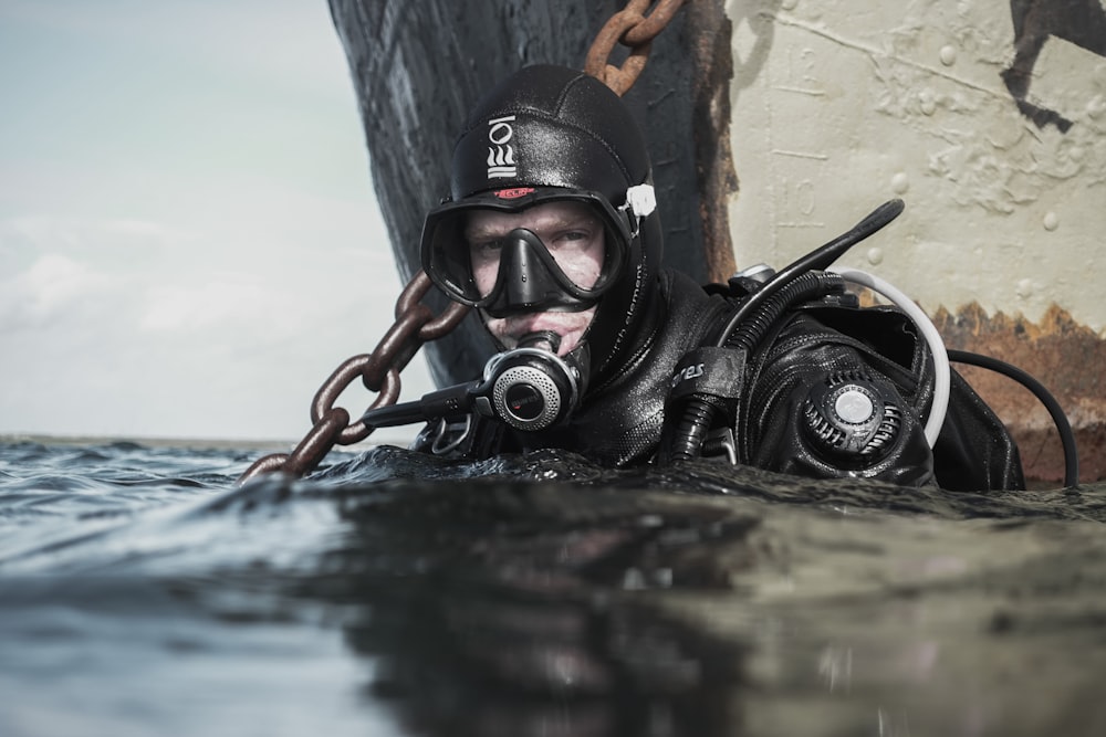 man wearing scuba diving on body of water