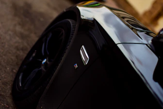 Close-up of a sleek black car being polished to a mirror shine.