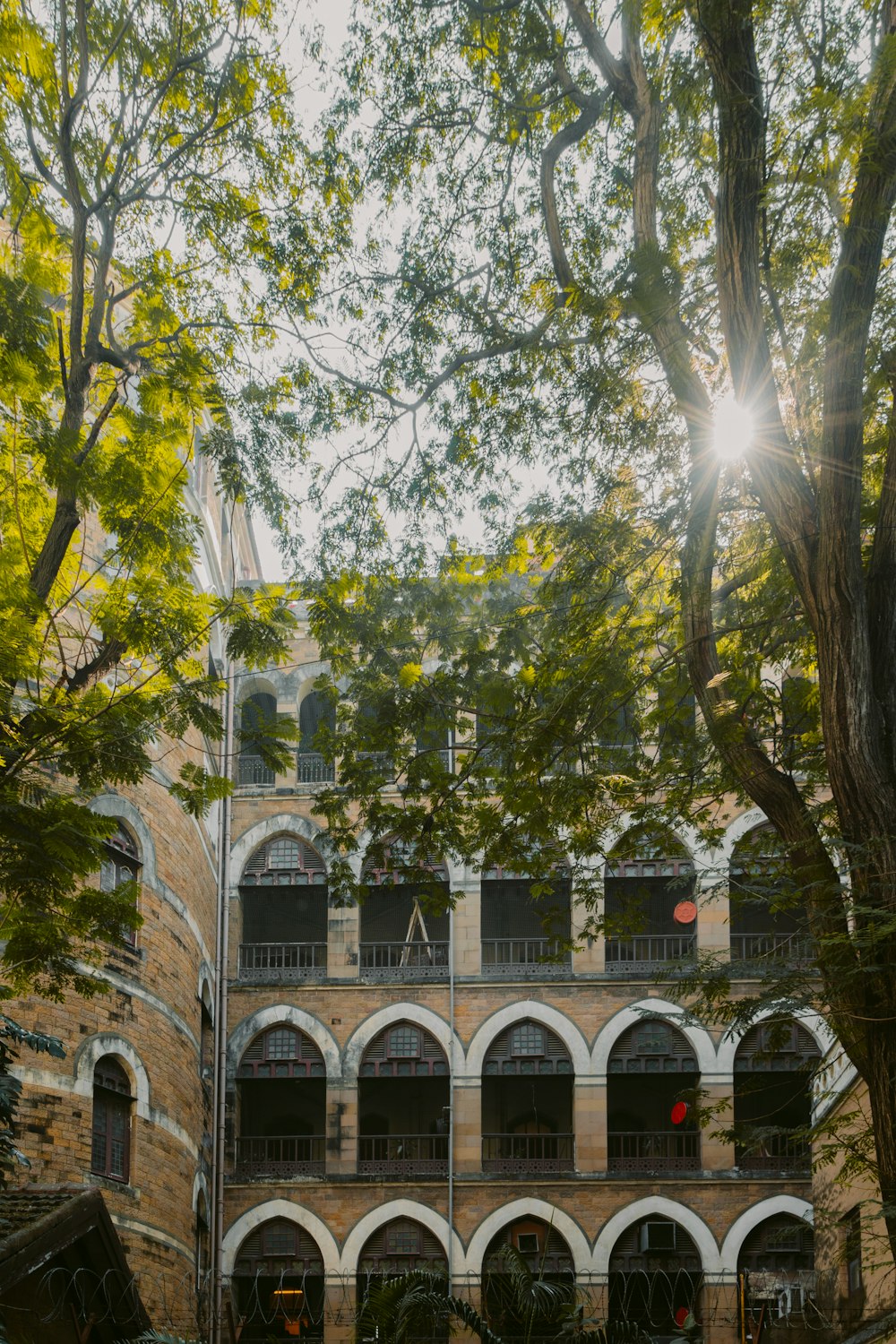the sun shines through the trees in front of a building