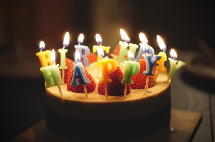 A birthday cake with letter shaped candles spelling out Happy Birthday