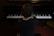 A child in formal attire is seated at a piano, playing the keys with both hands. The perspective is from behind, focusing on the posture and concentration of the child as they engage with the musical instrument. The piano is in a dimly lit room, creating an intimate atmosphere.