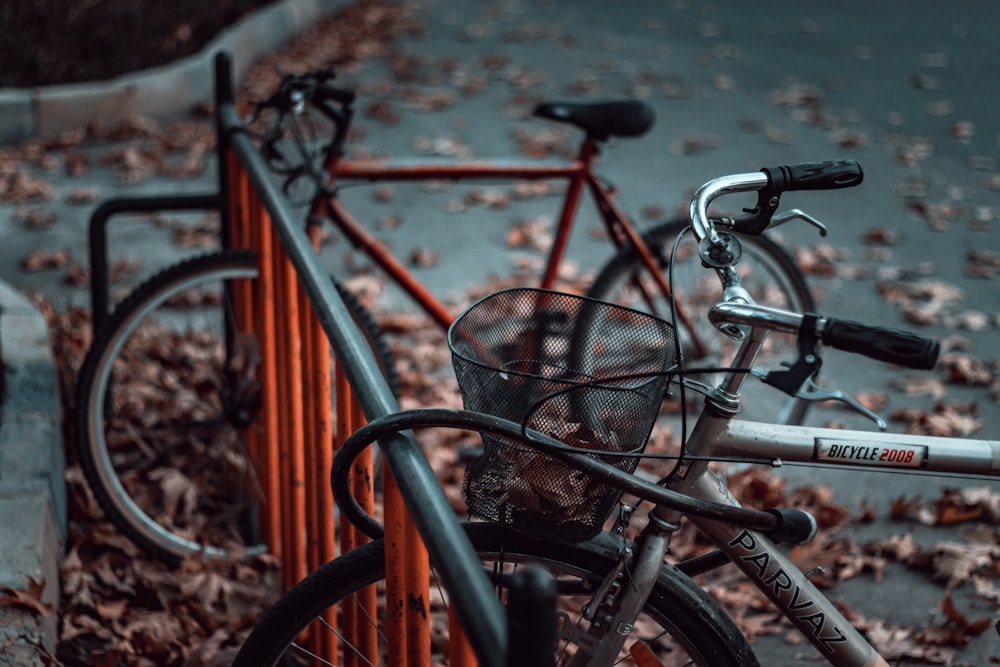 due biciclette grigie e rosse parcheggiate su portabici