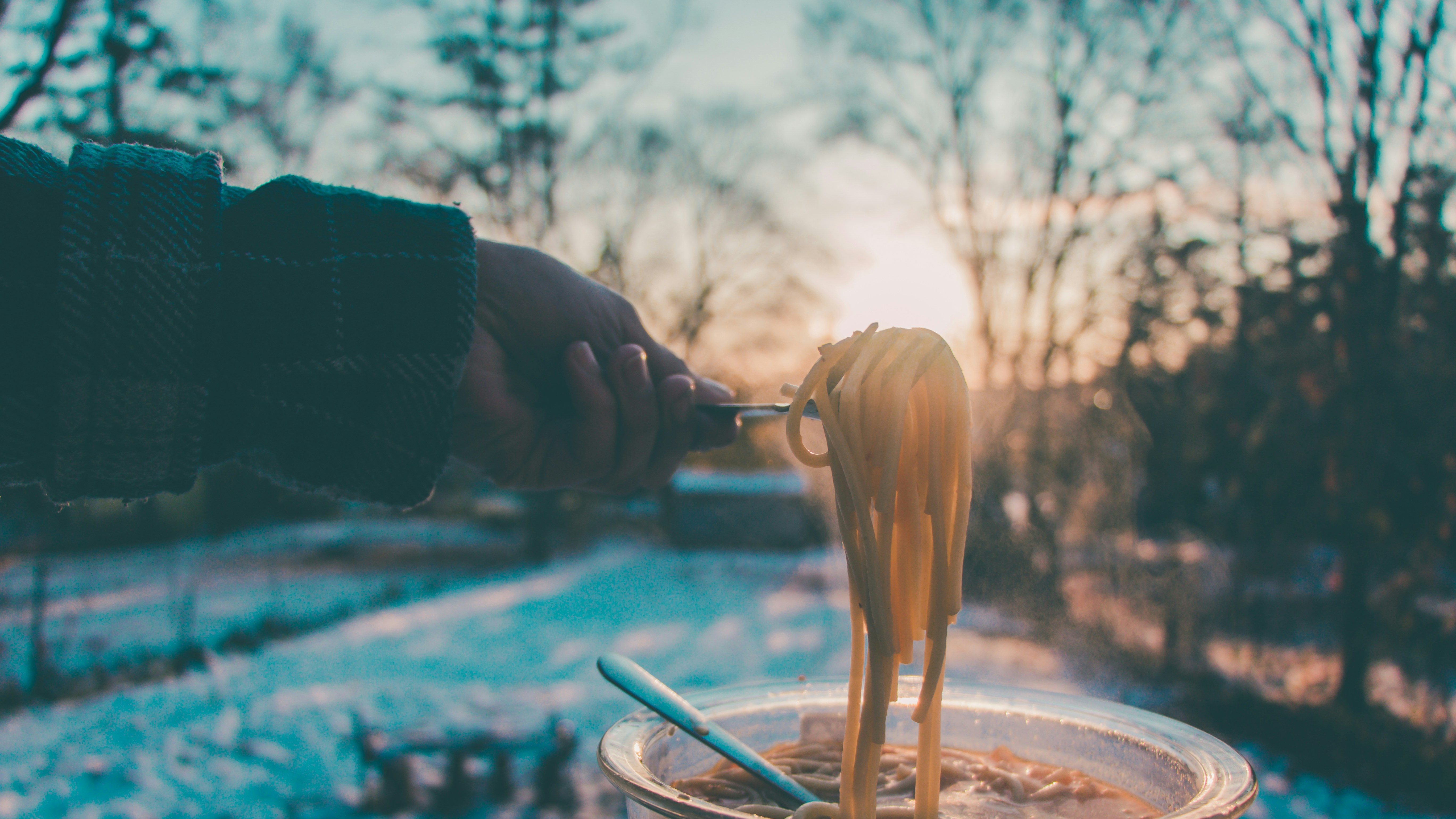 a person eating the Spaghetti during the winter season.