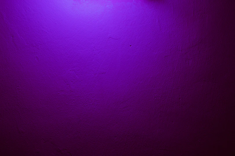 a purple wall with a clock on it