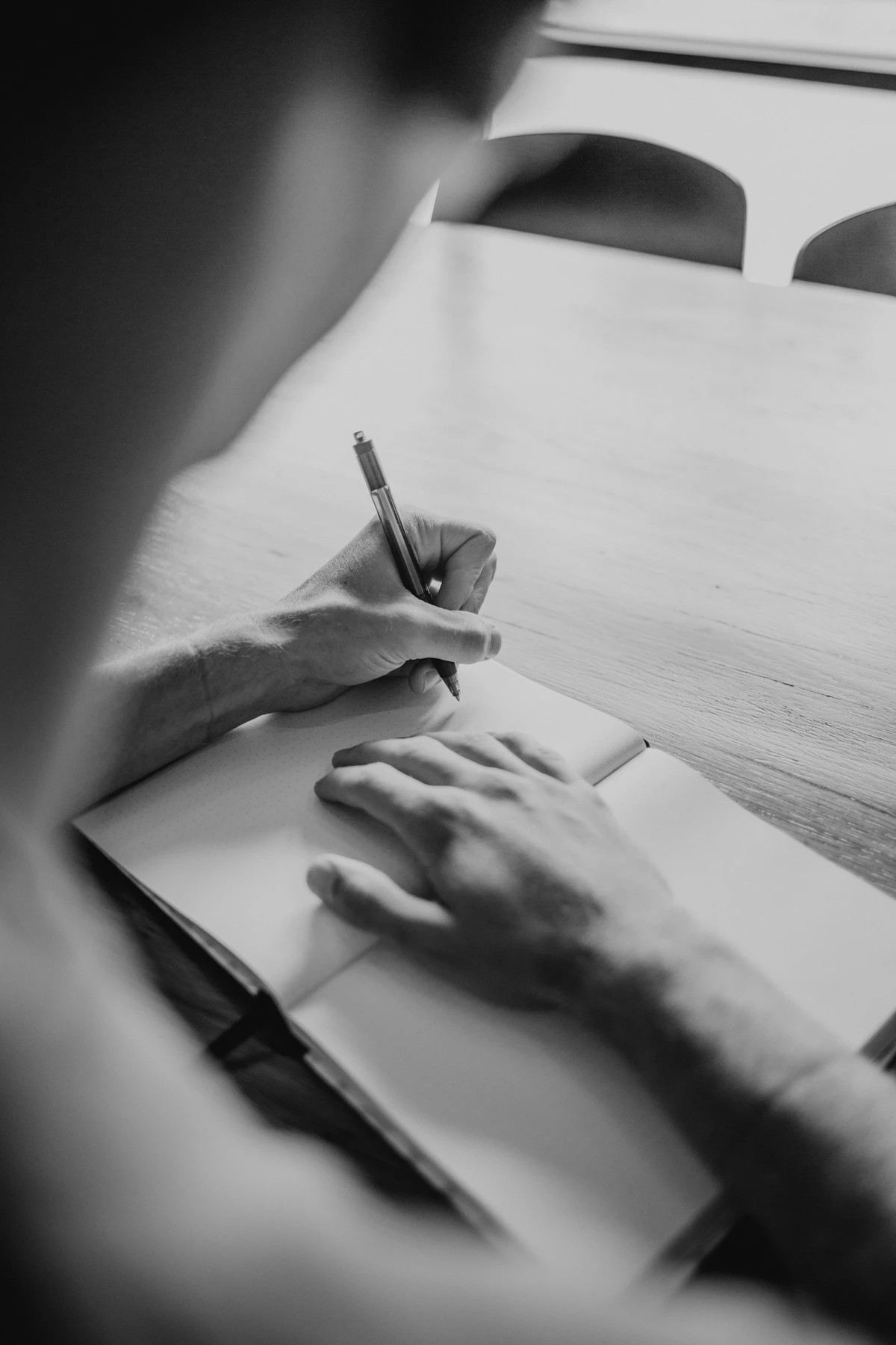 Person schreibt einen konkreten Plan in ein Notizbuch
