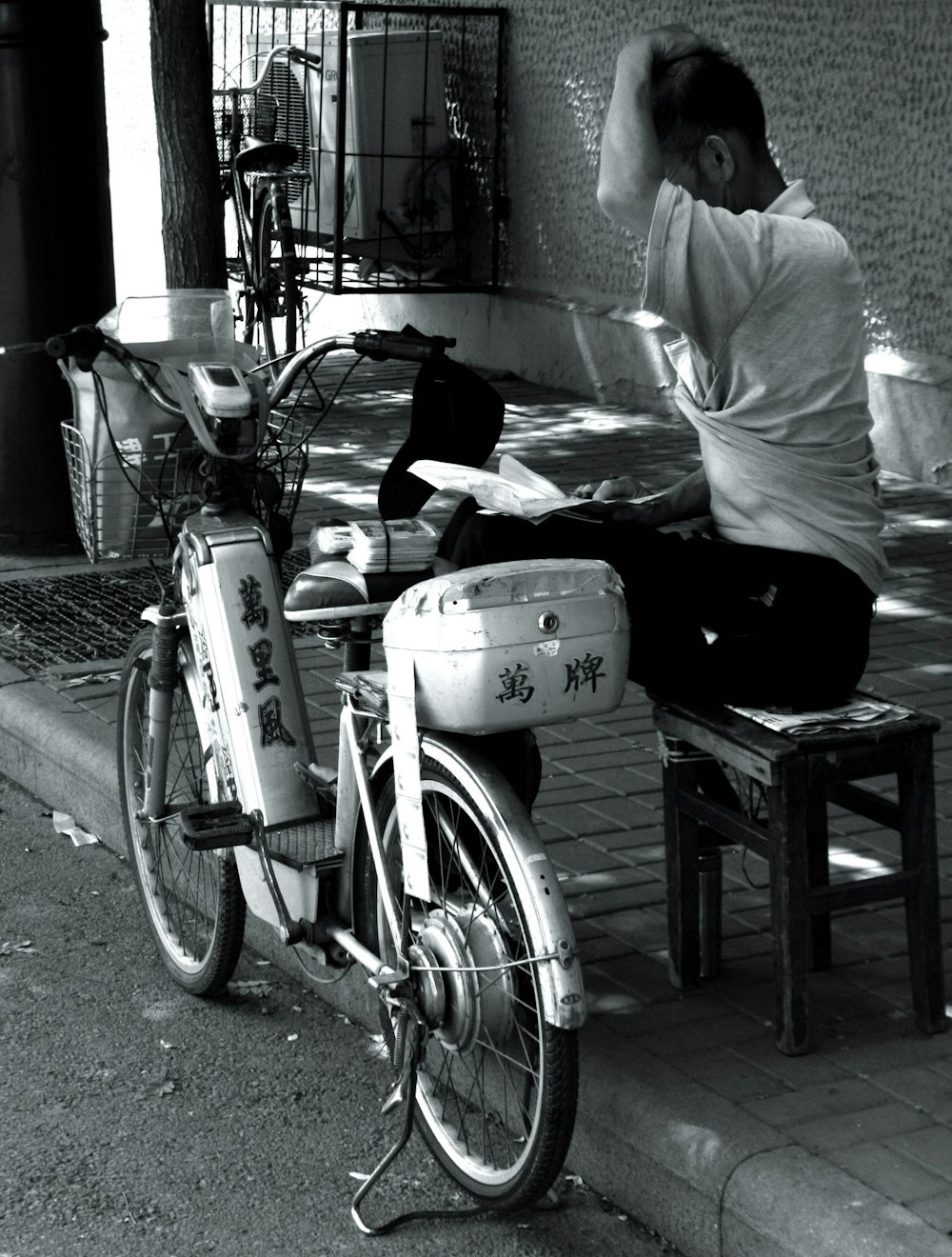 white pedal moped near man sitting on chair