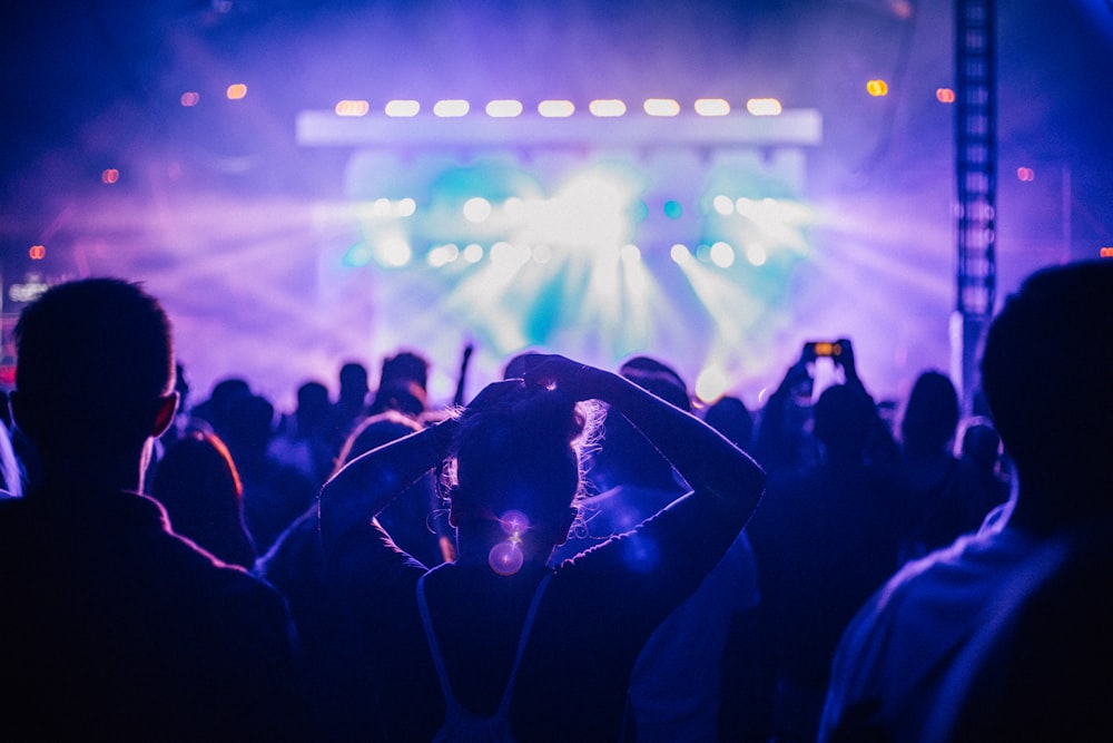 pessoas em pé na frente do palco com luzes