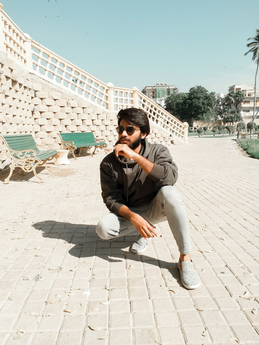 man crouching near empty benches