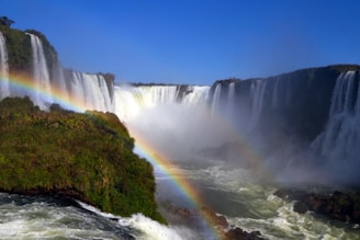 A stunning view of Victoria Falls with a rainbow arching over the cascading water.