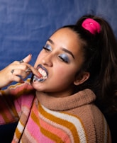A dental hygienist demonstrating proper flossing technique to a patient.