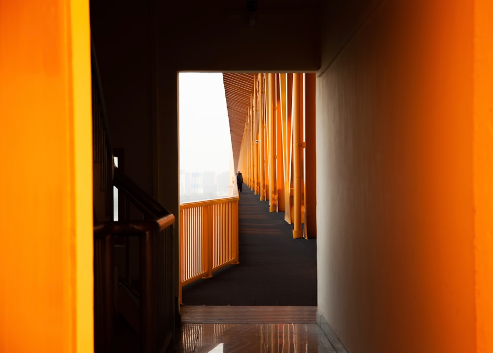 a hallway with orange curtains and a black floor