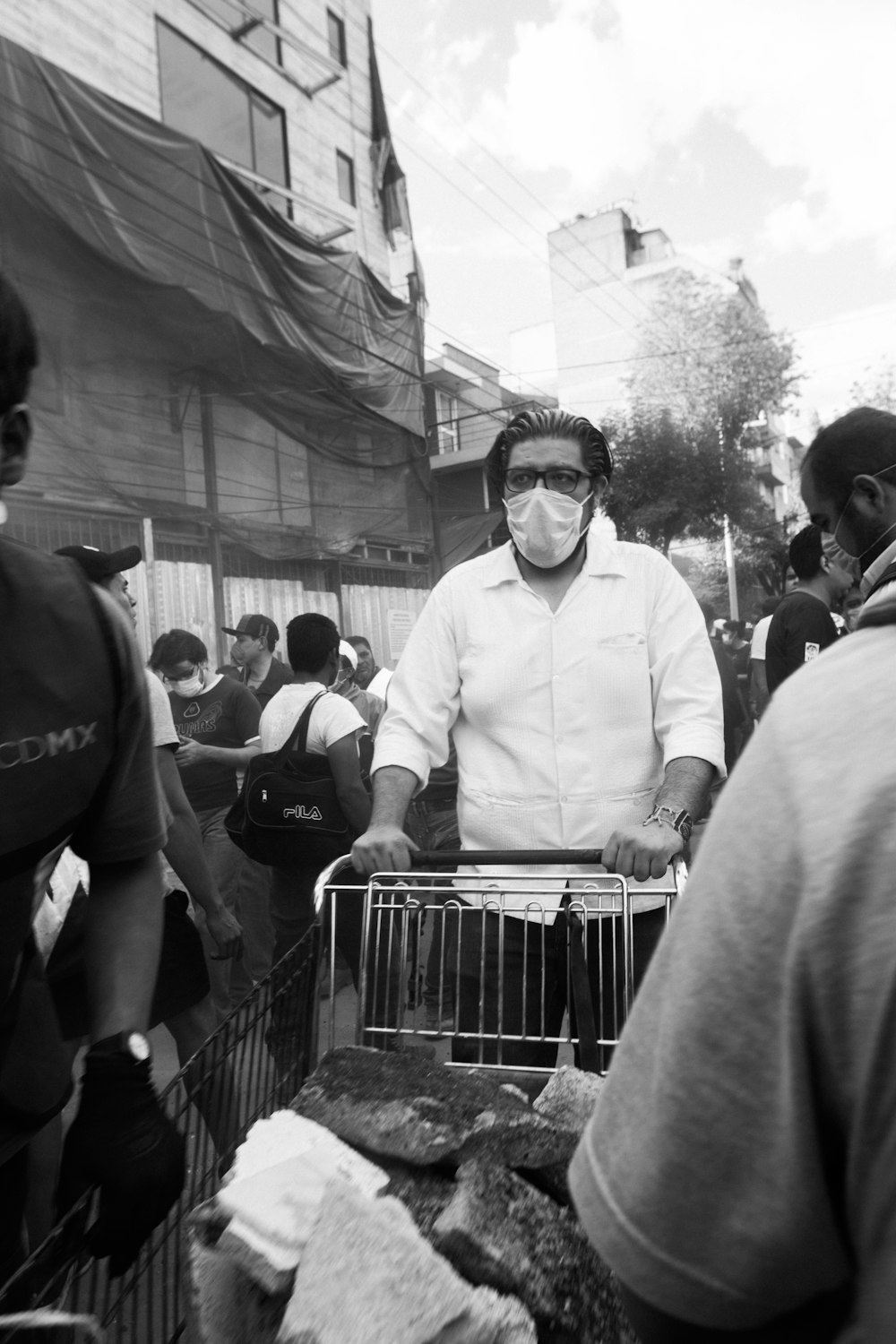 a man wearing a face mask standing in front of a shopping cart