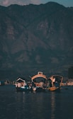 A family enjoying a scenic boat ride on a calm lake surrounded by mountains.