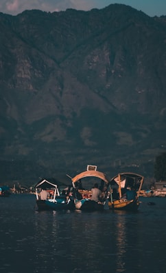 A family enjoying a scenic boat ride on a calm lake surrounded by mountains.