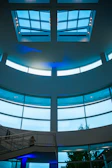 A futuristic BIM engineering studio with floor-to-ceiling glass walls and blue ambient lighting.