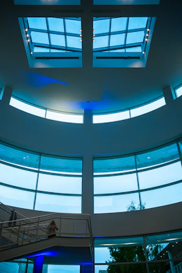 A futuristic BIM engineering studio with floor-to-ceiling glass walls and blue ambient lighting.