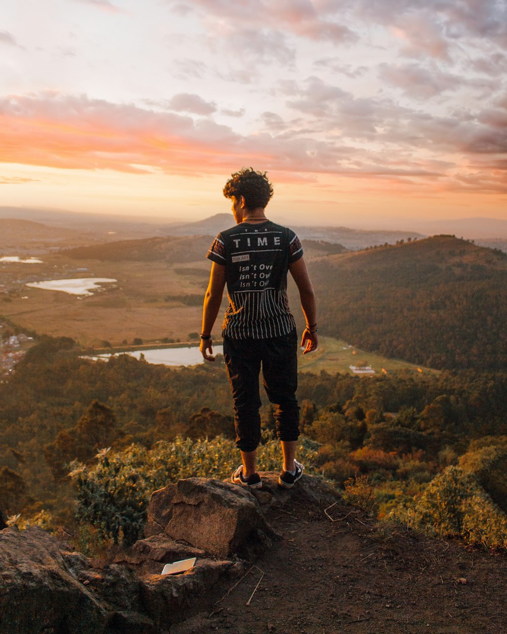 man wearing black shirt and pants standing on rock formation