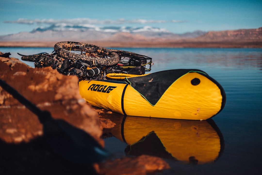 yellow and black Rogue inflatable boat carrying bicycle