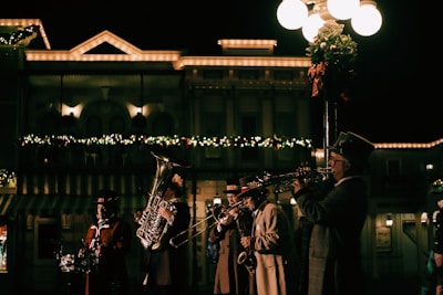 A group of street artists playing traditional instruments under city lights.