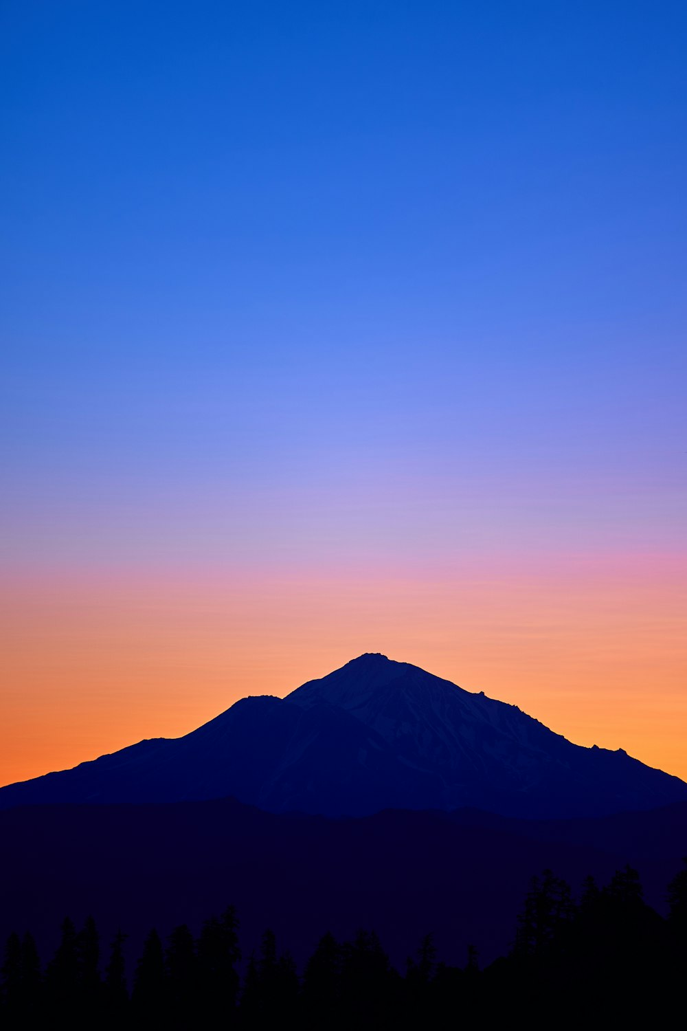 Montaña del cono bajo el cielo naranja y azul