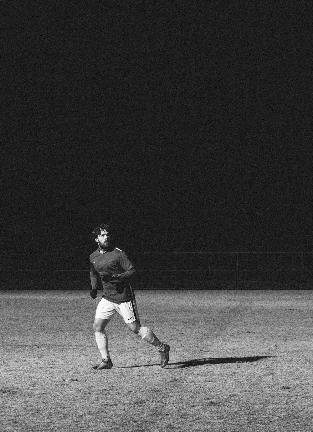 man wearing black sweater running at grass field