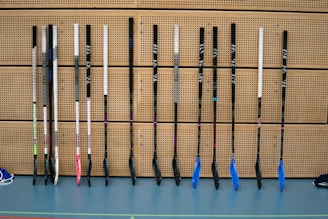 Hockey sticks lined up on the rink's bench as the team gears up for their session.