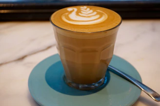 Freshly brewed café latte with delicate latte art in a cozy café setting.