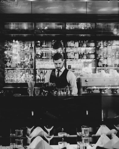 grayscale photography of man holding wine glass