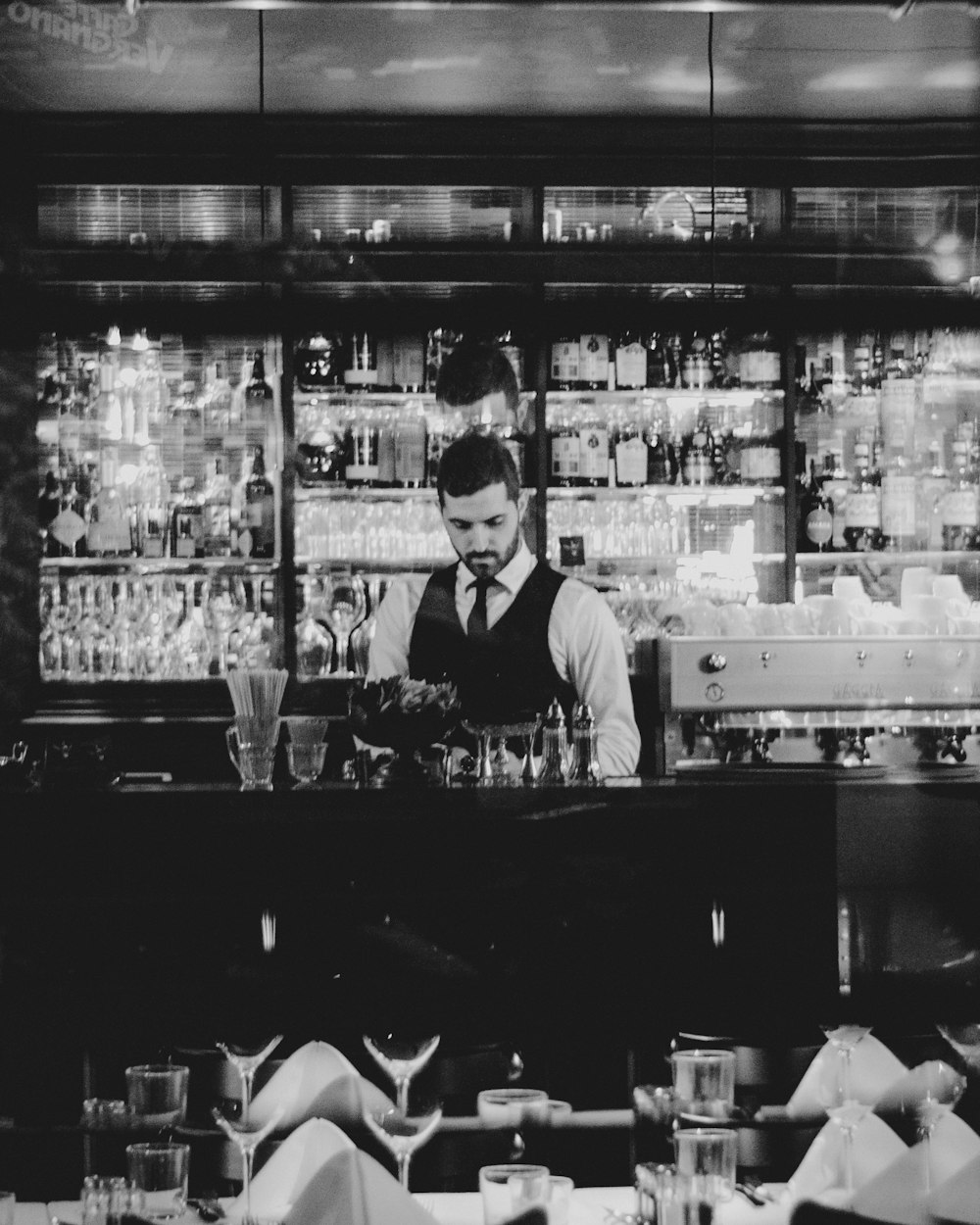 grayscale photography of man holding wine glass