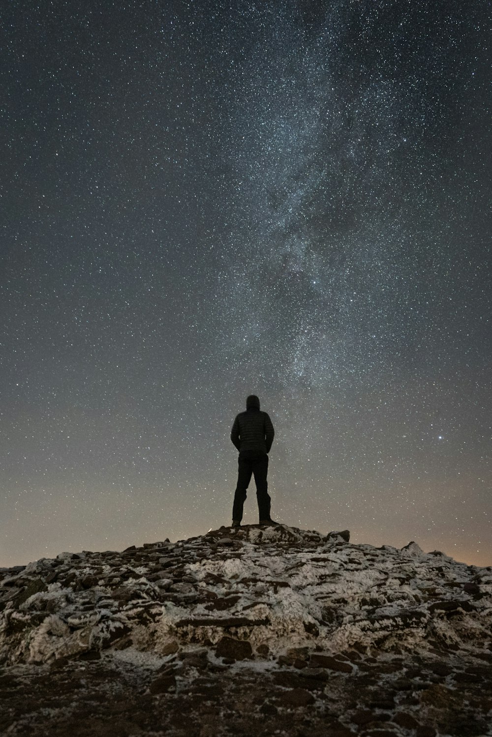 man standing on cliff duirng nighttime