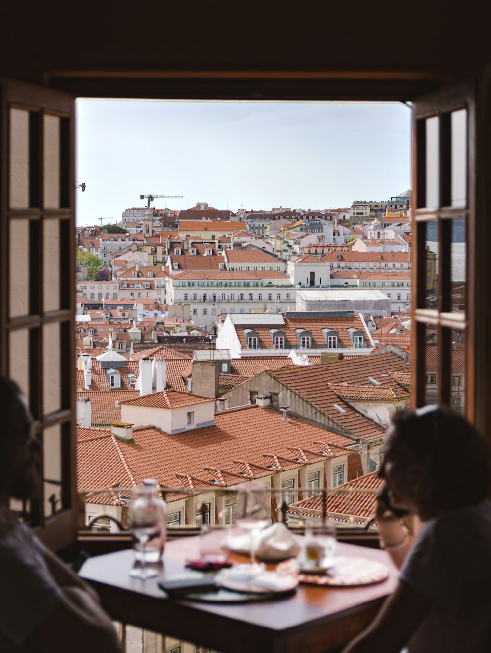 two people sitting at a table in front of a window